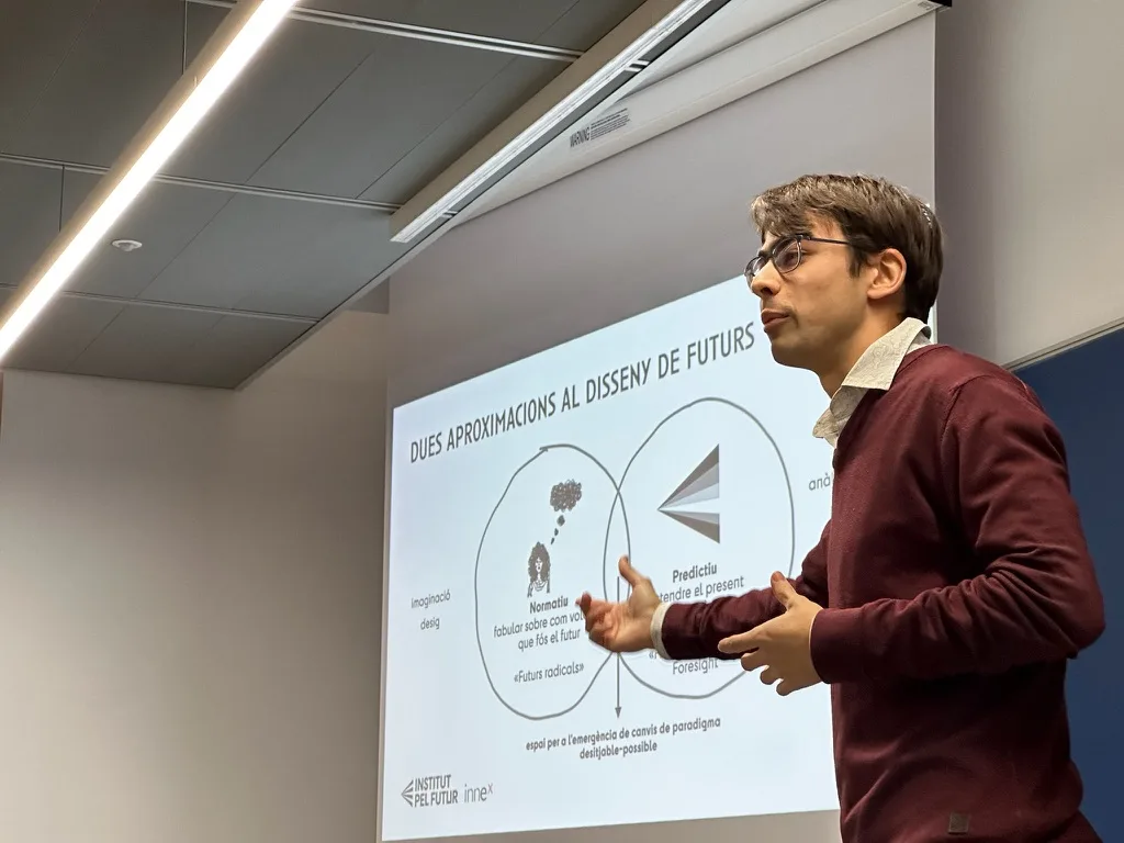 Una persona fent una formació davant d’una projecció sobre disseny de futurs.